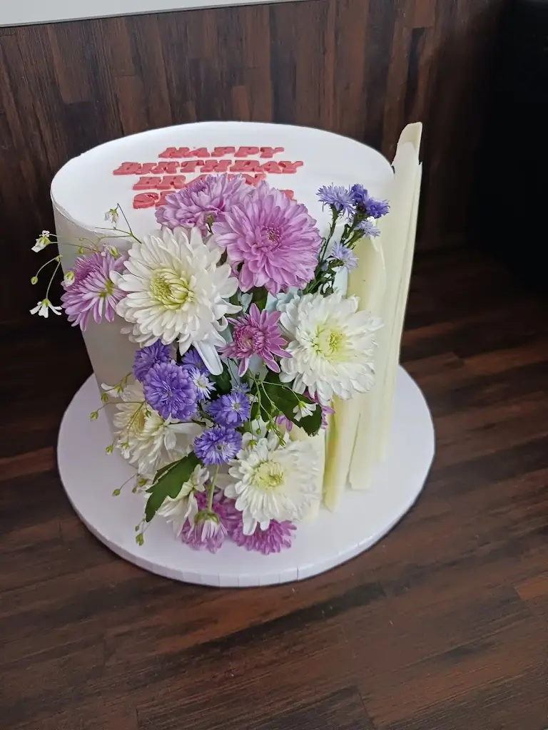 Elegant birthday cake decorated with fresh purple and white flowers by Blue Heaven, online cake delivery in Bhopal